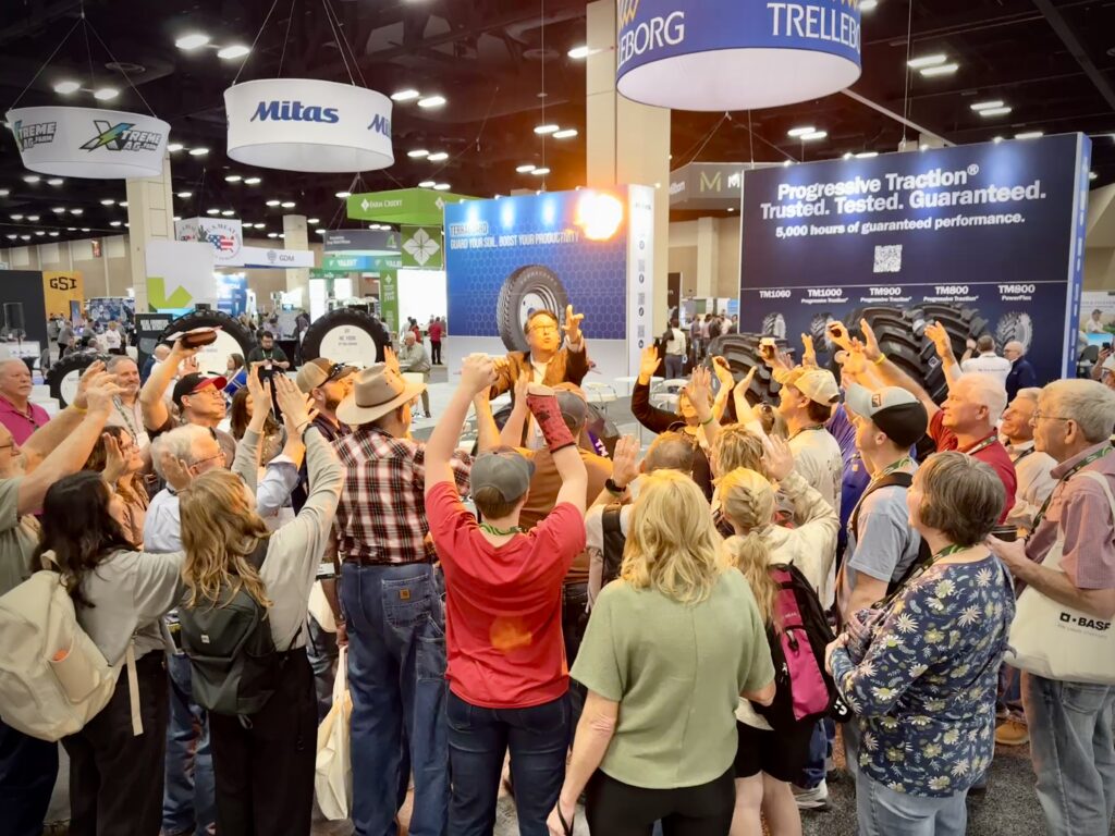 Crowds of interested attendees are magically pulled from the aisles into the exhibit